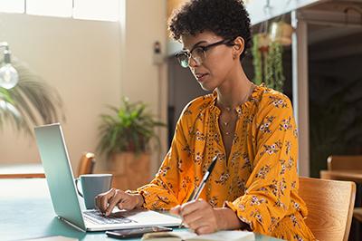 woman-yellow-shirt-on-latop-writing